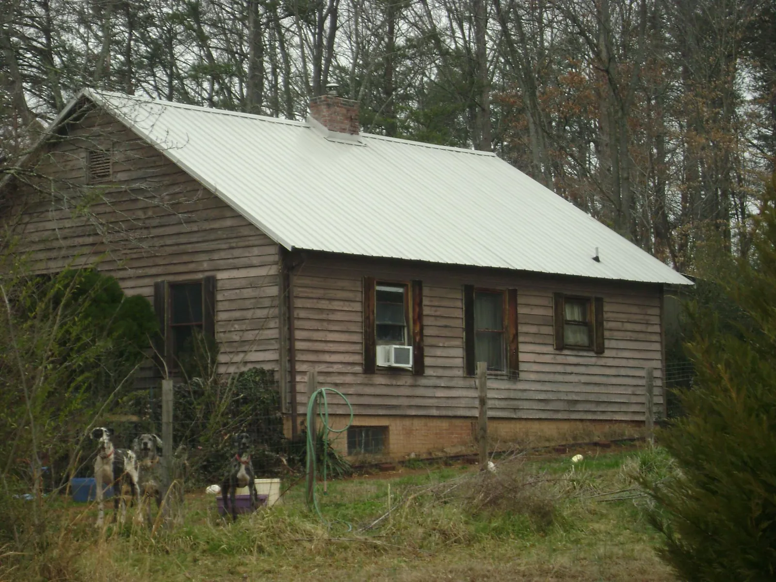 White metal roof on an old wood sided farmhouse, from a Metal Roof Installation job in Pittsburg
